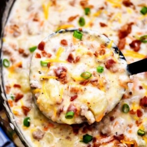 An image of a pot of bacon cheeseburger soup with more soup in a ladle.