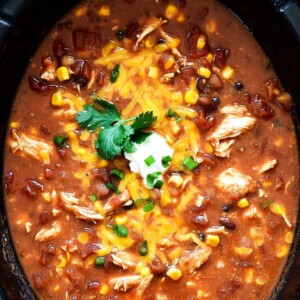 An image of a pot of chicken taco soup with sour cream and cheese on top.