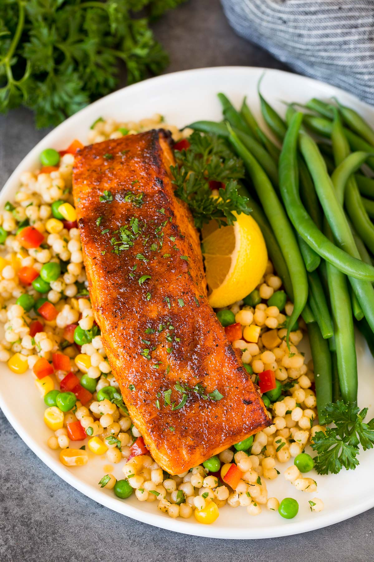 Salmon fillet baked with salmon seasoning served with couscous and green beans.