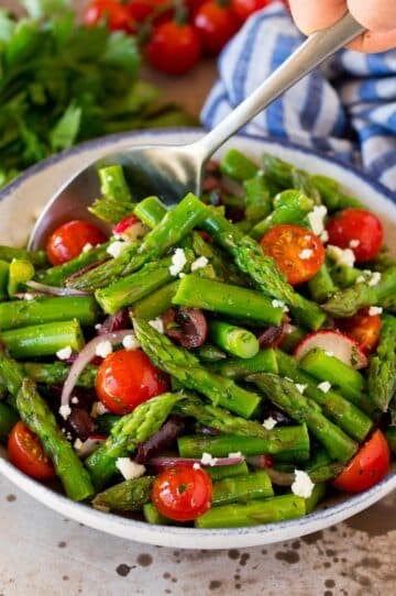 Asparagus salad with a serving spoon in it.