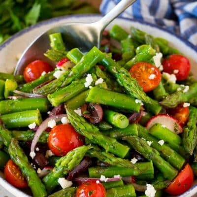 Asparagus salad with a serving spoon in it.