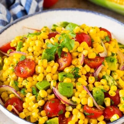 Avocado corn salad in a serving bowl topped with cilantro.