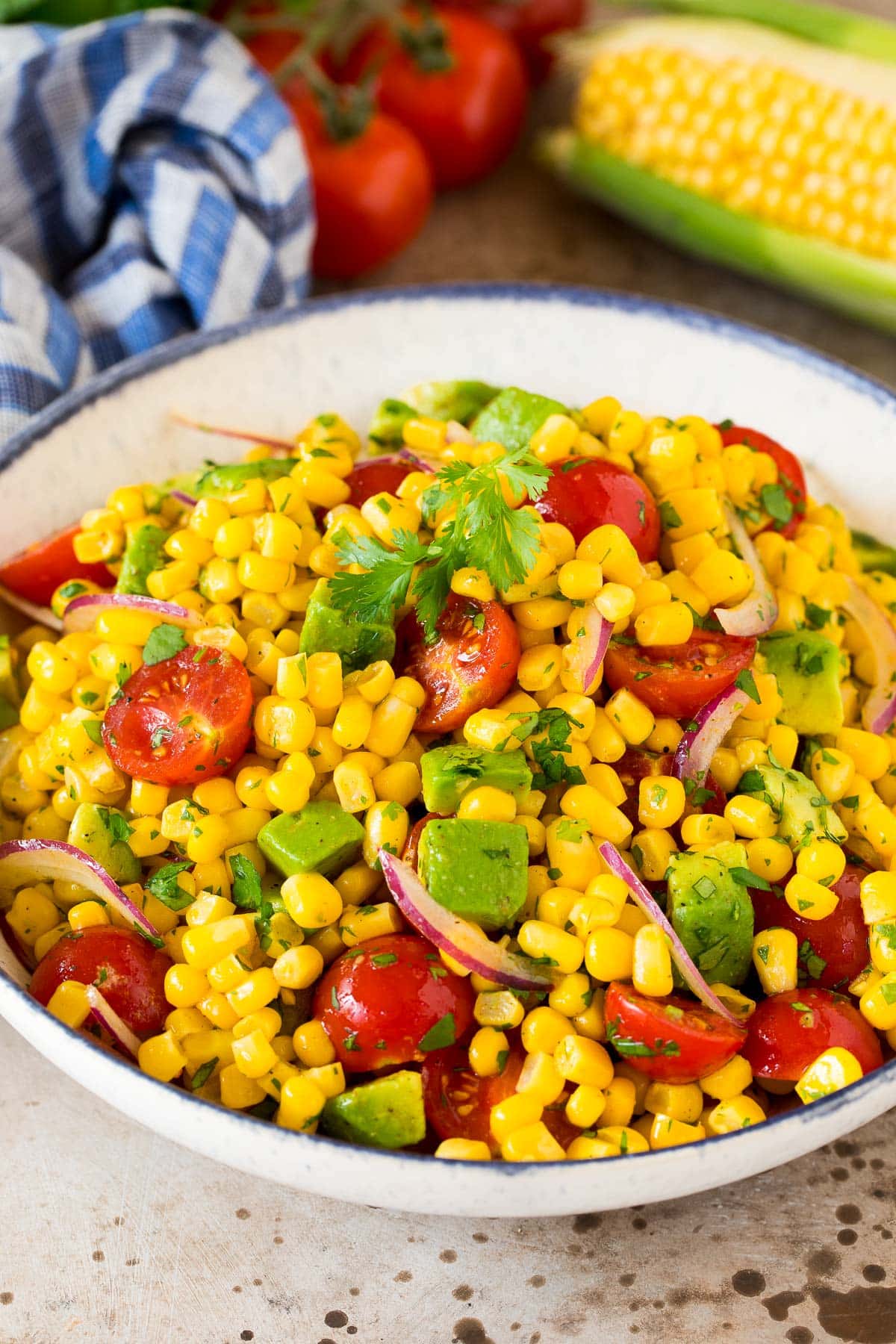 Avocado corn salad in a serving bowl topped with cilantro.