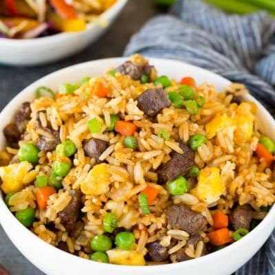 A bowl of beef fried rice topped with green onions.