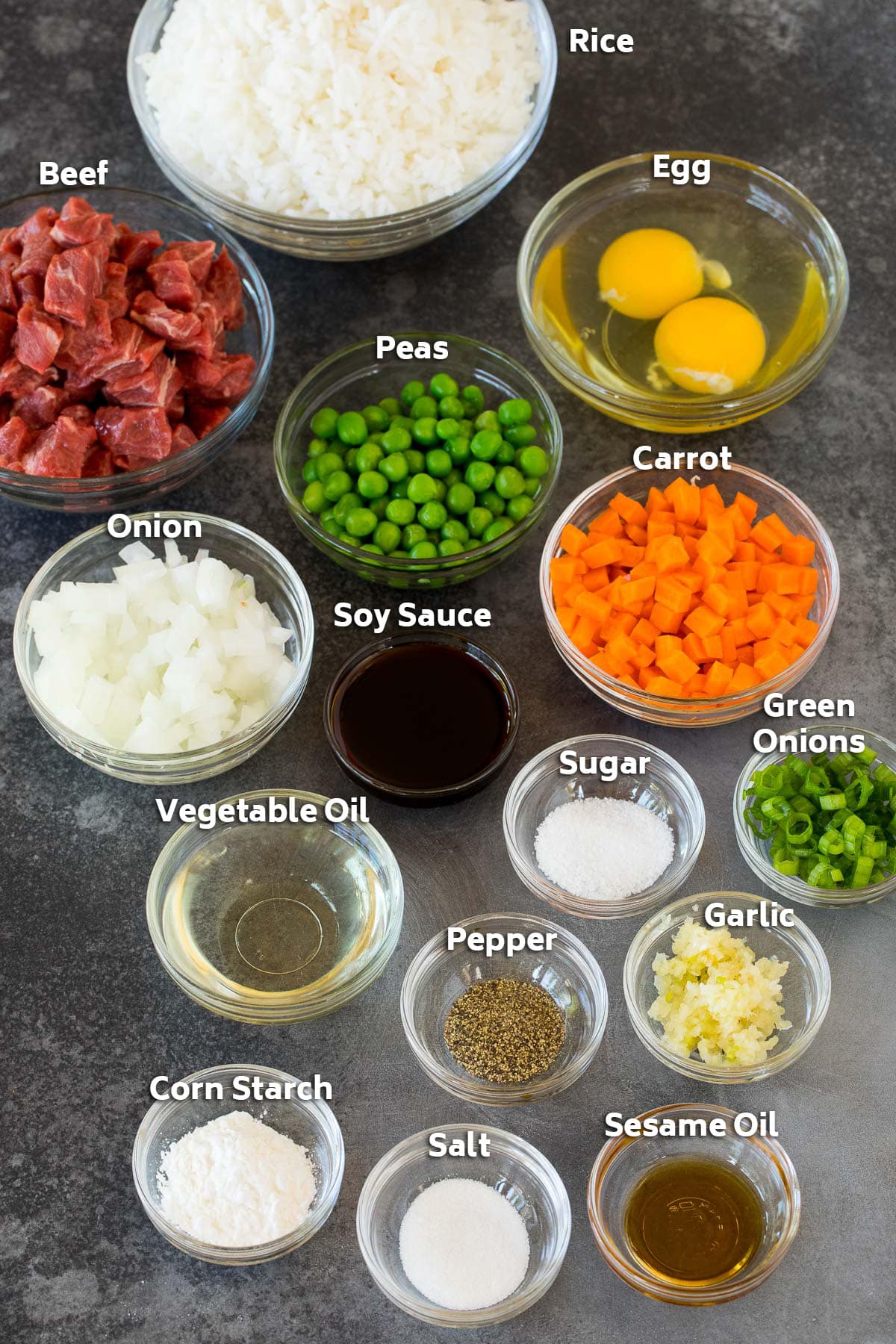 Bowls of ingredients including steak, rice, vegetables and seasonings.