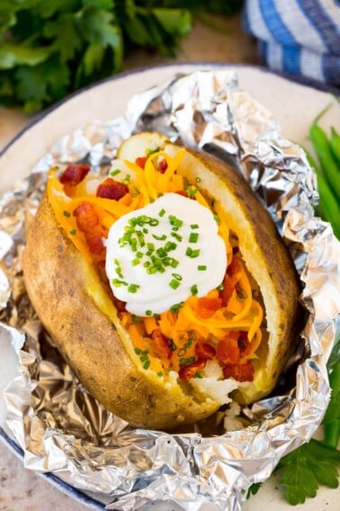 Crock pot baked potatoes topped with sour cream and bacon.