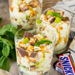 Individual servings of snicker apple salad garnished with caramel and mint.