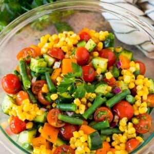 A bowl of chopped vegetable salad garnished with parsley.