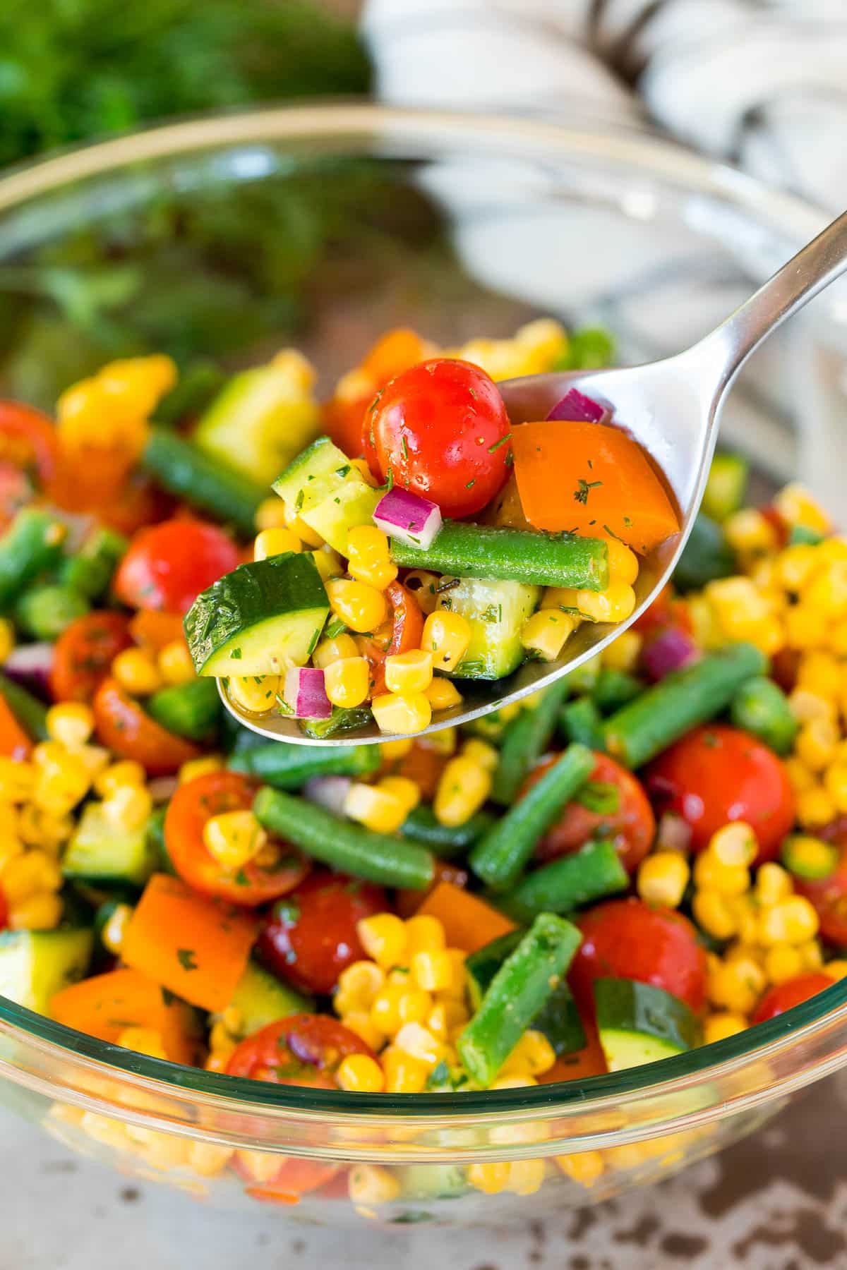 A spoon serving up a portion of vegetable salad.