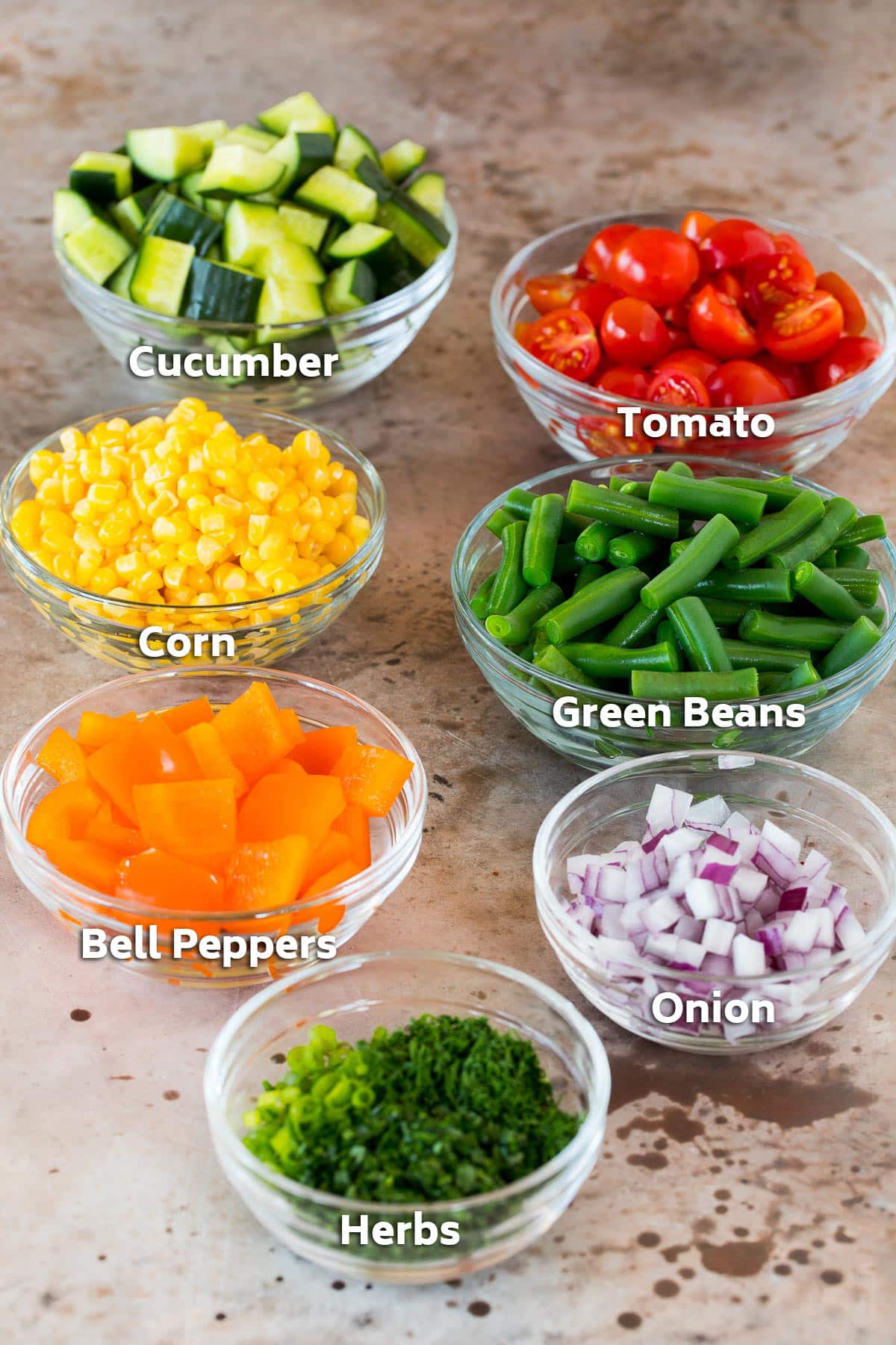 Bowls of vegetables including corn, green beans and tomatoes.