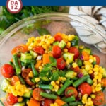 This vegetable salad is a fresh and colorful blend of chopped corn, cucumbers, tomatoes, red onion, peppers and green beans, all tossed together with fresh herbs in a homemade dressing.