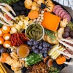 A Halloween charcuterie board filled with meats, cheeses, crackers and Halloween sweets.