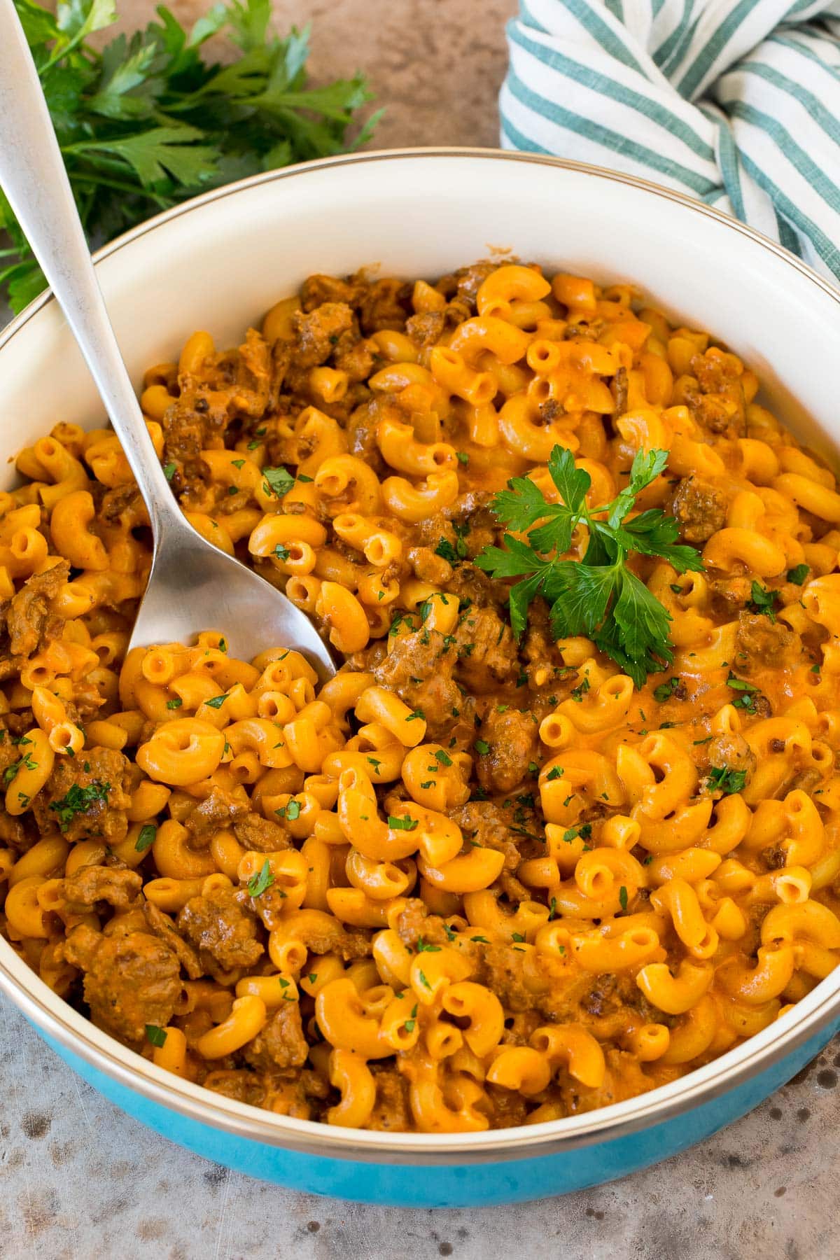 A pan of homemade hamburger helper with a spoon in it.