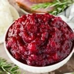 A bowl of Instant Pot cranberry sauce garnished with rosemary.
