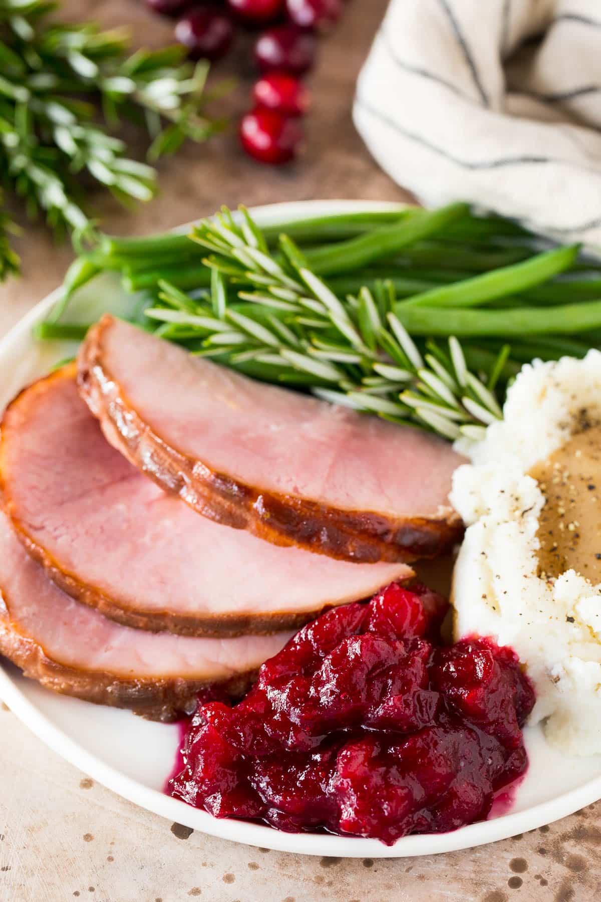 Instant Pot cranberry sauce on a plate with ham and green beans.