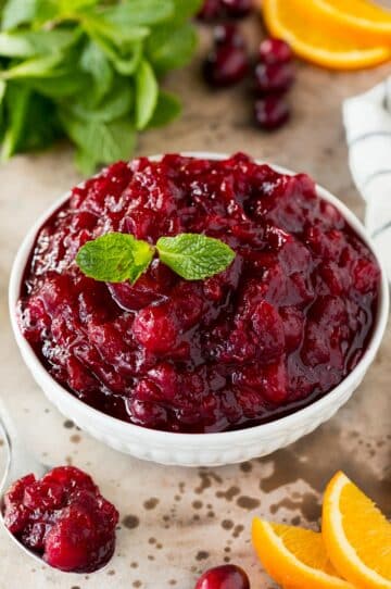 A bowl of slow cooker cranberry sauce garnished with mint.