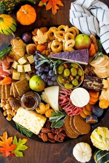 A Thanksgiving charcuterie board made with meats, cheeses, crackers, fruit and fall themed sweets.