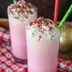 A picture of a two candy cane milkshakes with whipped cream on top.