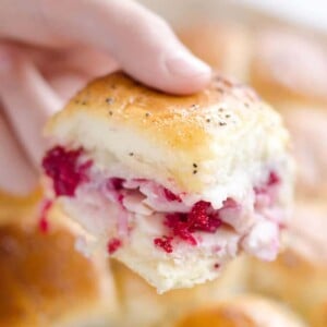 An image of a turkey baked slider held by a hand.