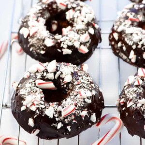 An image of chocolate peppermint baked donuts on a wire rack.