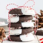 A picture of several dark chocolate candy cane cookies stacked on a table.