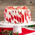 An image of a white chocolate candy cane cake on a platter.