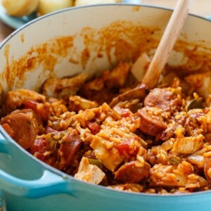 An image of a pot of chicken jambalaya with a wooden spoon in it.