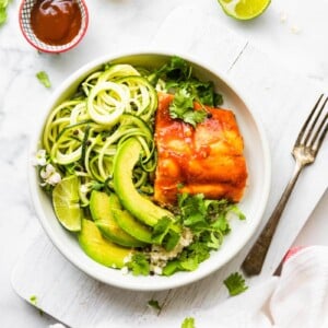 A bowl of BBQ salmon with zucchini and avocado.