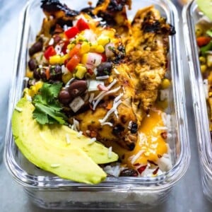 A picture of a glass container with coconut mango chicken.