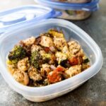 A picture of a container of Italian style chicken and vegetables.