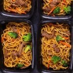 An image of beef lo mein in black containers.