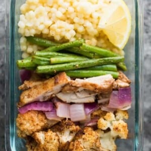 A picture of couscous with chicken and veggies.