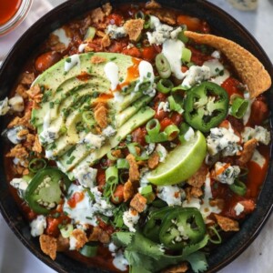 A picture of buffalo chicken chili with avocado slices on top.