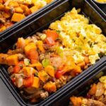 An image of a breakfast meal prep with eggs and sweet potato and sausage hash.