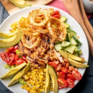 An image of a BBQ chicken salad on a white plate.