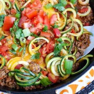 A picture of zucchini noodles with Mexican taco style meat, cheese and veggies.