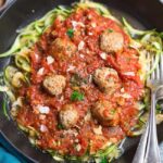 An image of zucchini noodles with meatballs and marinara sauce.