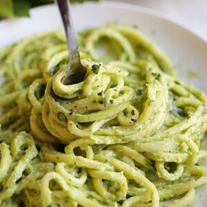 An image of a fork twirling avocado pesto zoodles.