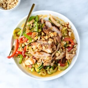 An image of drunken zucchini noodles with spice honey chicken in a bowl.