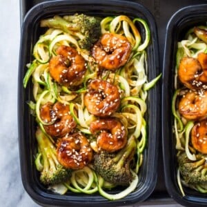 An image of containers with prepared meals of shrimp zoodles with broccoli.