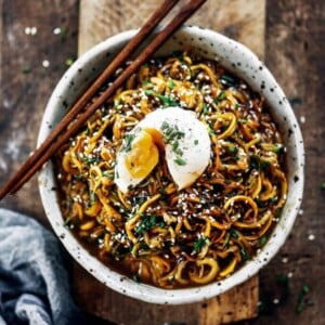 An image of an Asian zucchini noodle bowl with a soft boiled egg on top.