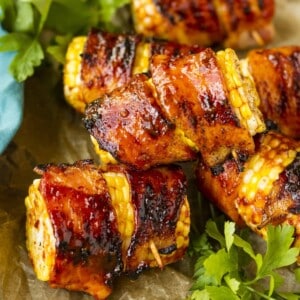 An image of corn on the cob pieces with bacon wrapping them.