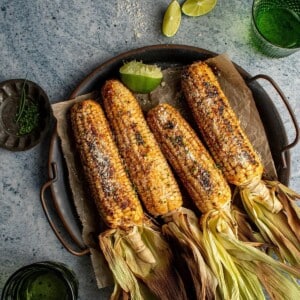 An image of 4 ears of blackened corn on the cob on a plate.