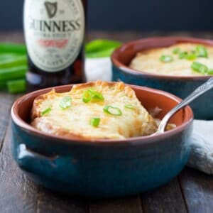 An image of Guinness soup in a bowl with cheese on top.