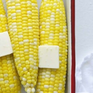 An image of microwaved corn on the cob with butter on top.
