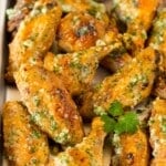 A pan of garlic parmesan wings garnished with parsley.