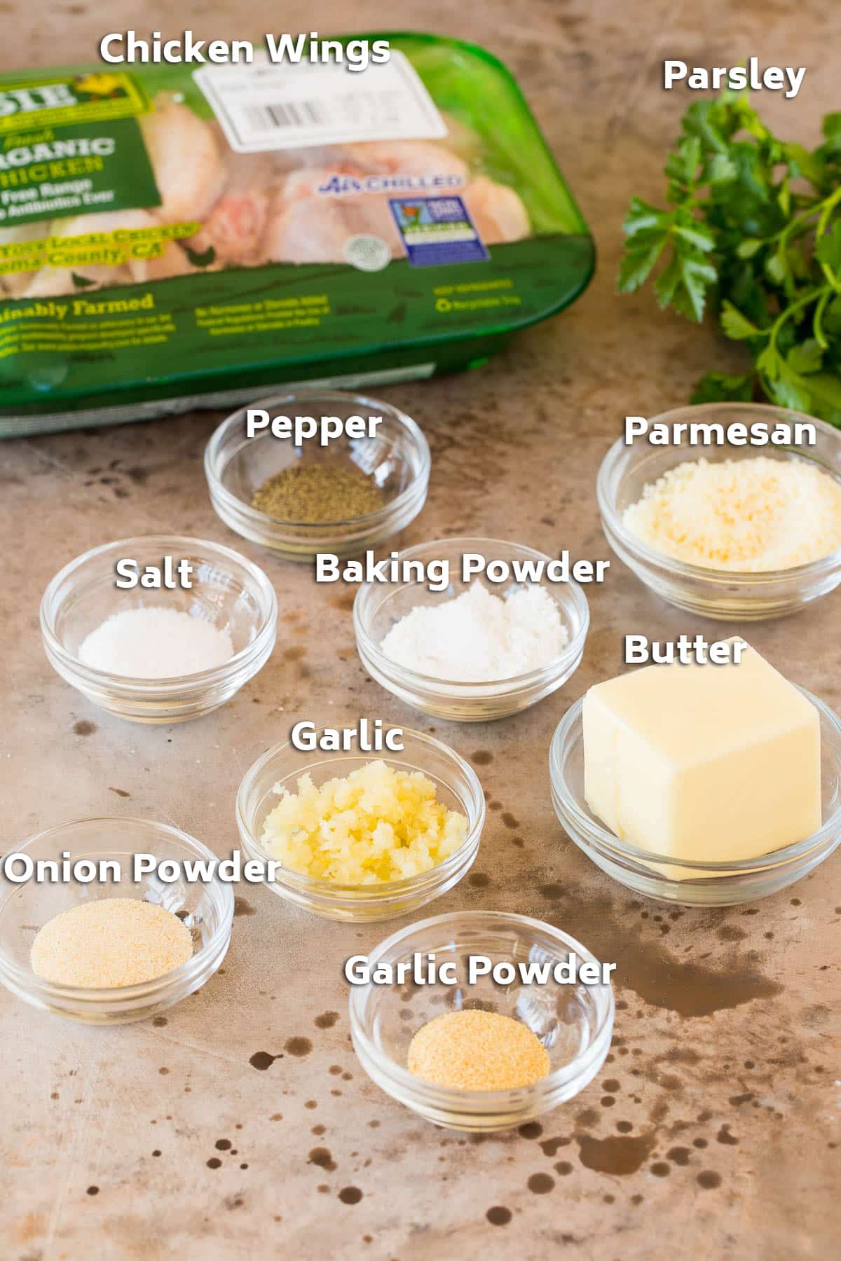 Ingredients including chicken wings, butter, seasonings and parmesan.