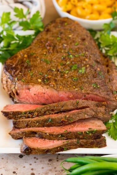 London broil on platter partially sliced.