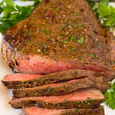 London broil on platter partially sliced.