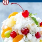 A picture of ambrosia salad which is a variety of colorful fruit with marshmallows and coconut, tossed in a light and creamy dressing.